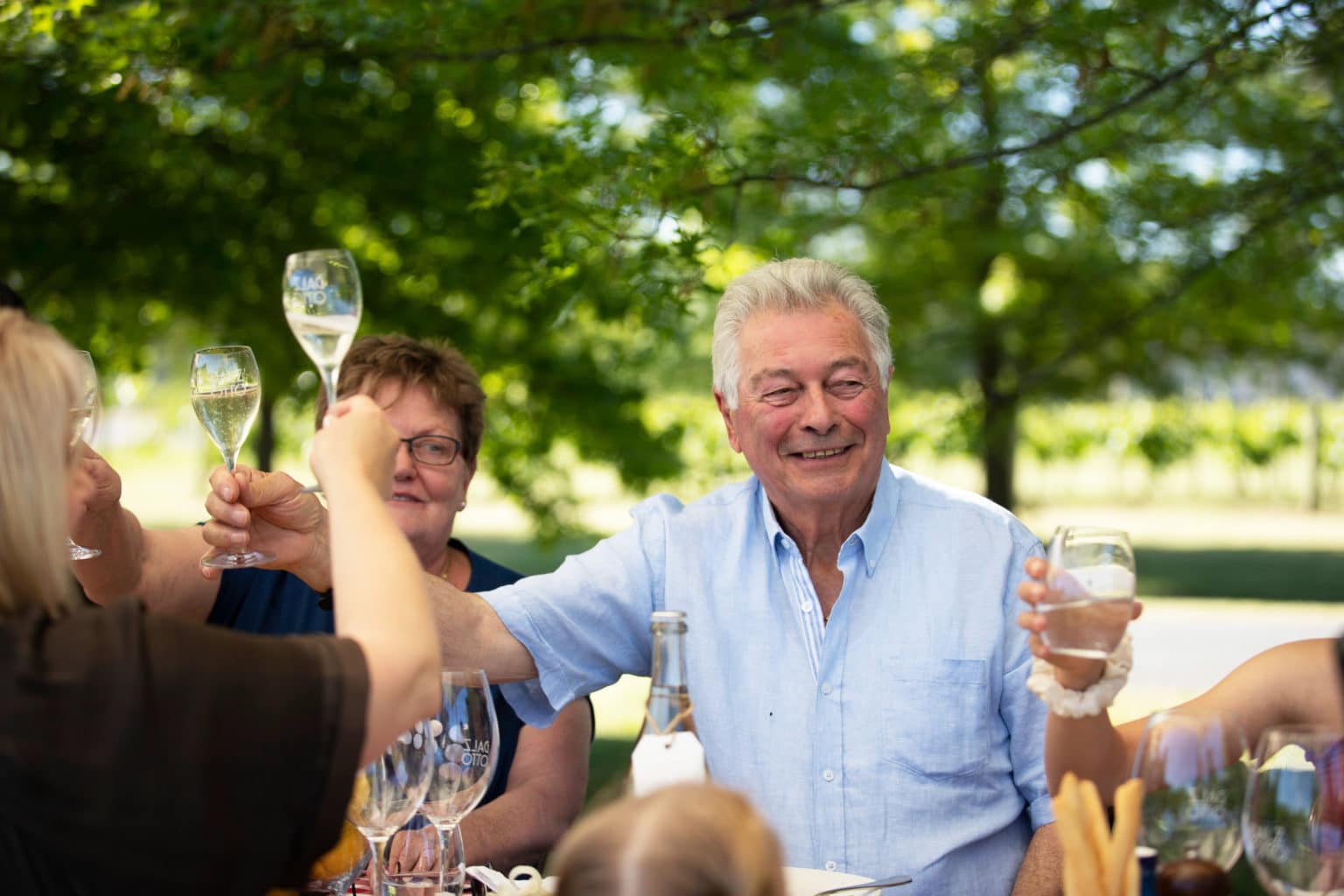 Otto and Elena Dal Zotto feasting, cheers with a glass of Prosecco