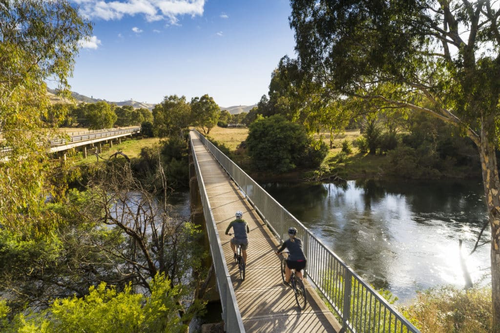 Two cyclists riding along a footbridge on the Great Victorian Rail Trail