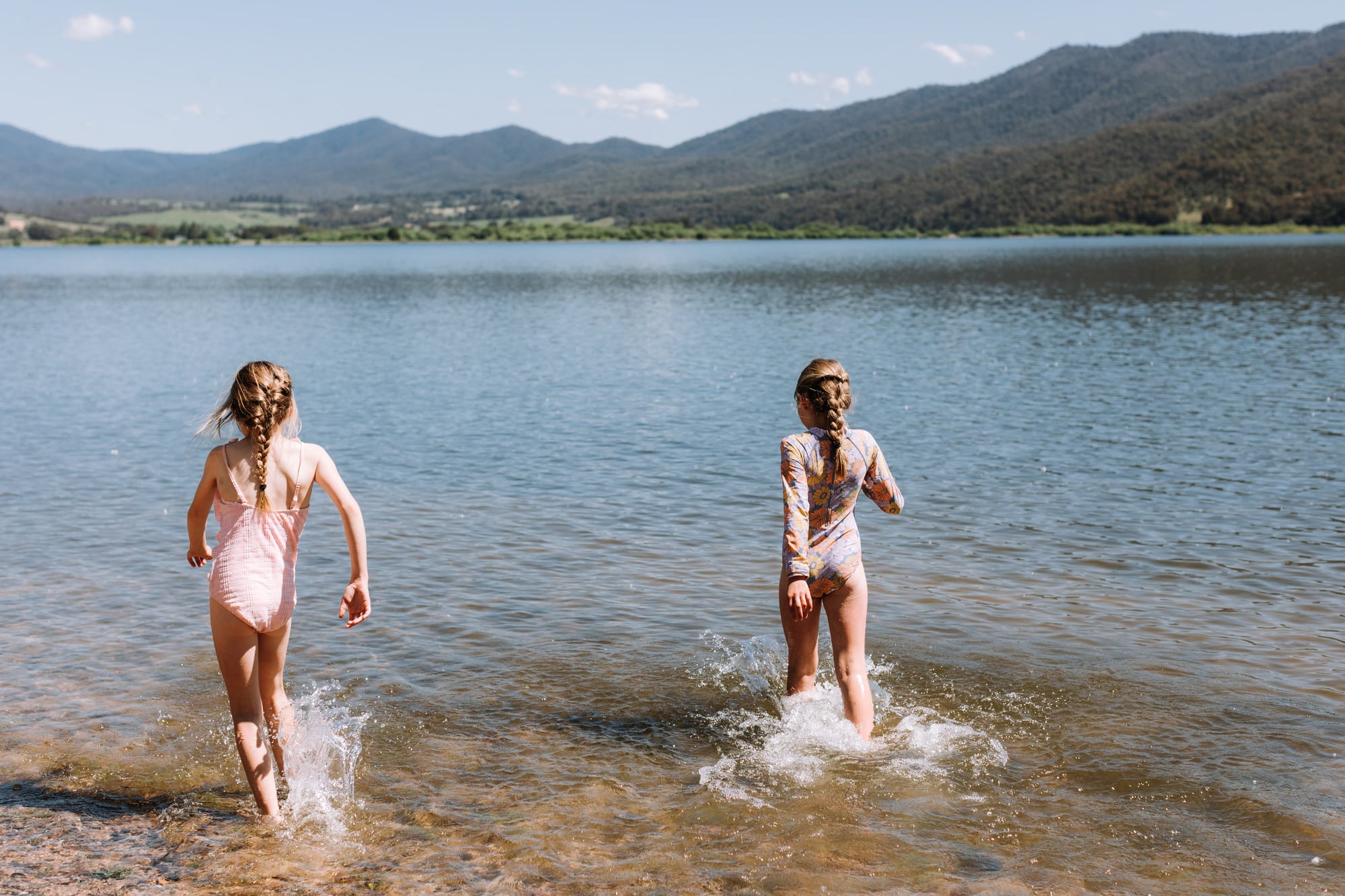 Two children running into Lake Hume to go swimming
