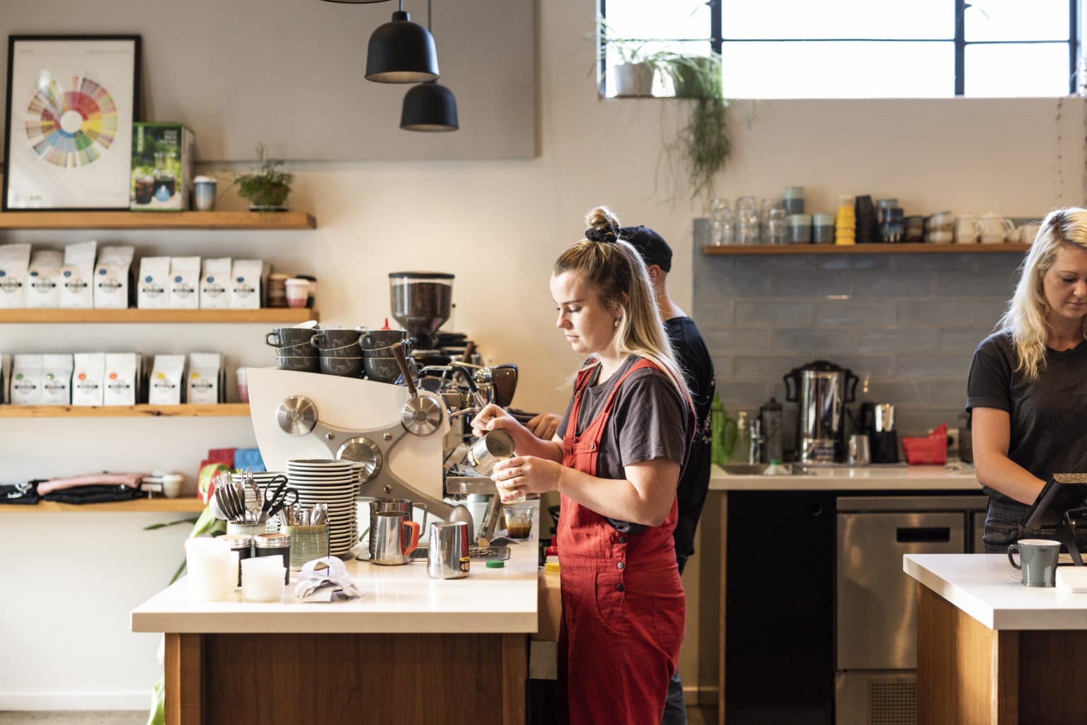 A female barista making a coffee at Sixpence Cafe, Bright.