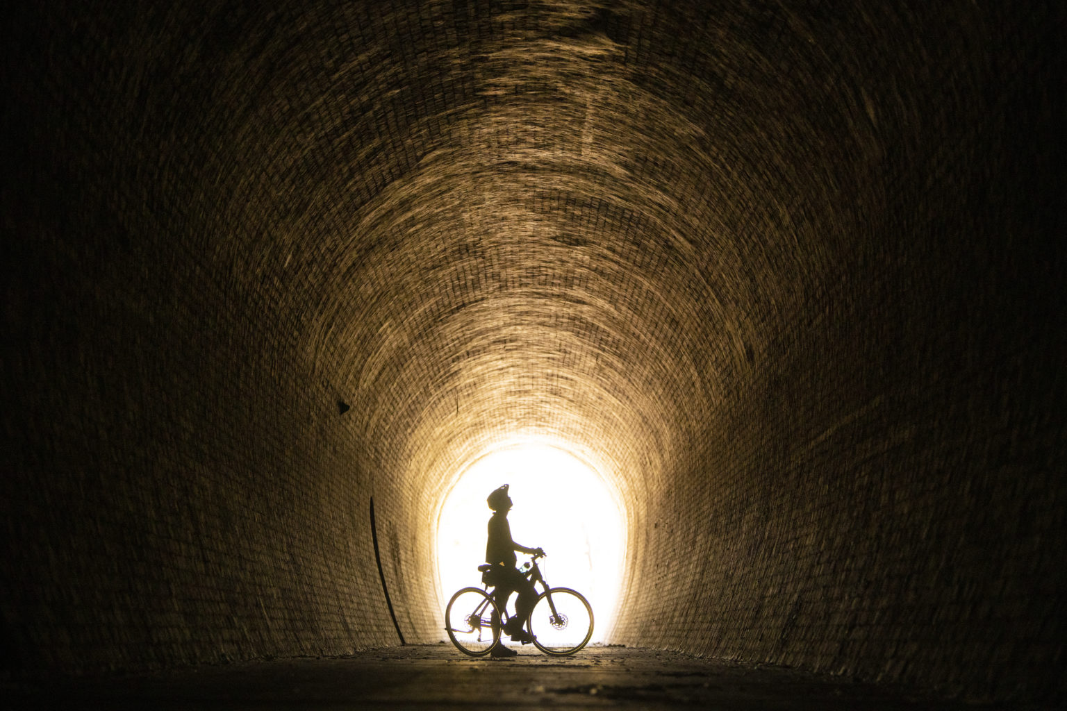 A lone cyclist in the Cheviot Tunnel, rail trail cycling