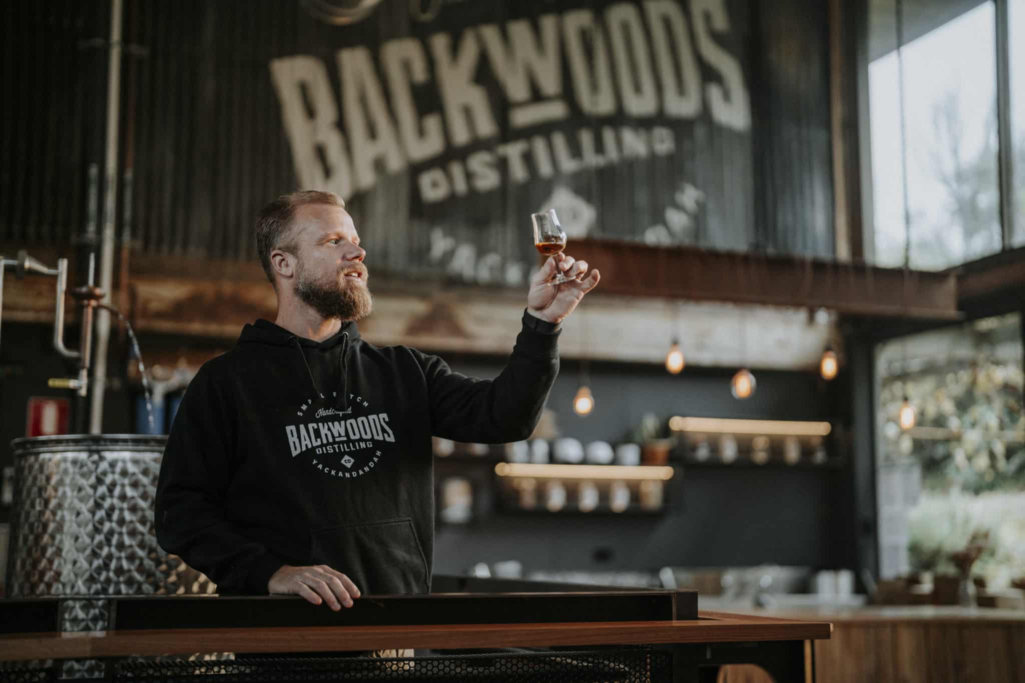 A distiller sampling whiskey, Backwoods Distillery.