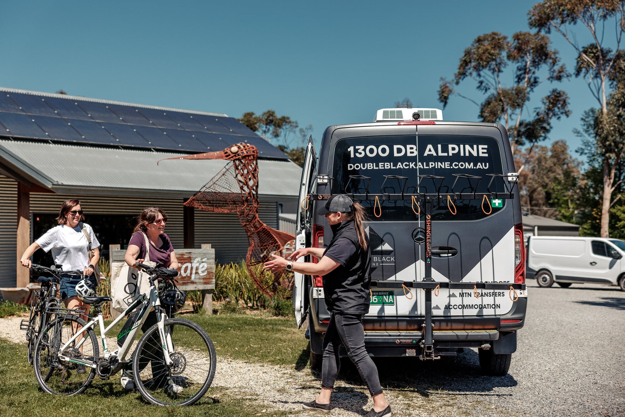 Two cyclists getting picked up by Double Black Alpine shuttle and tour company