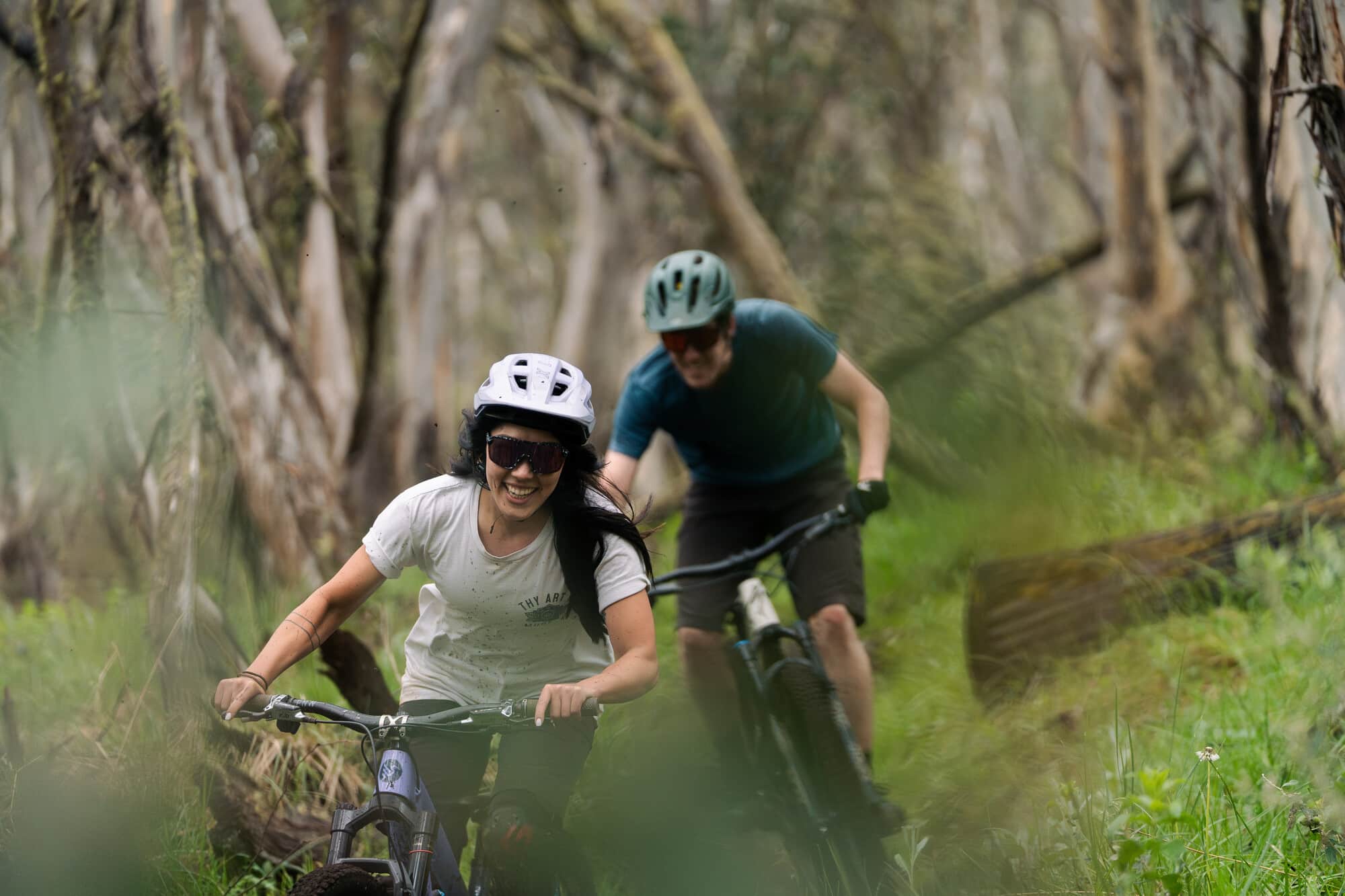 Two cyclists weaving through beautiful snow gums at Dinner Plain Mountain Bike Park