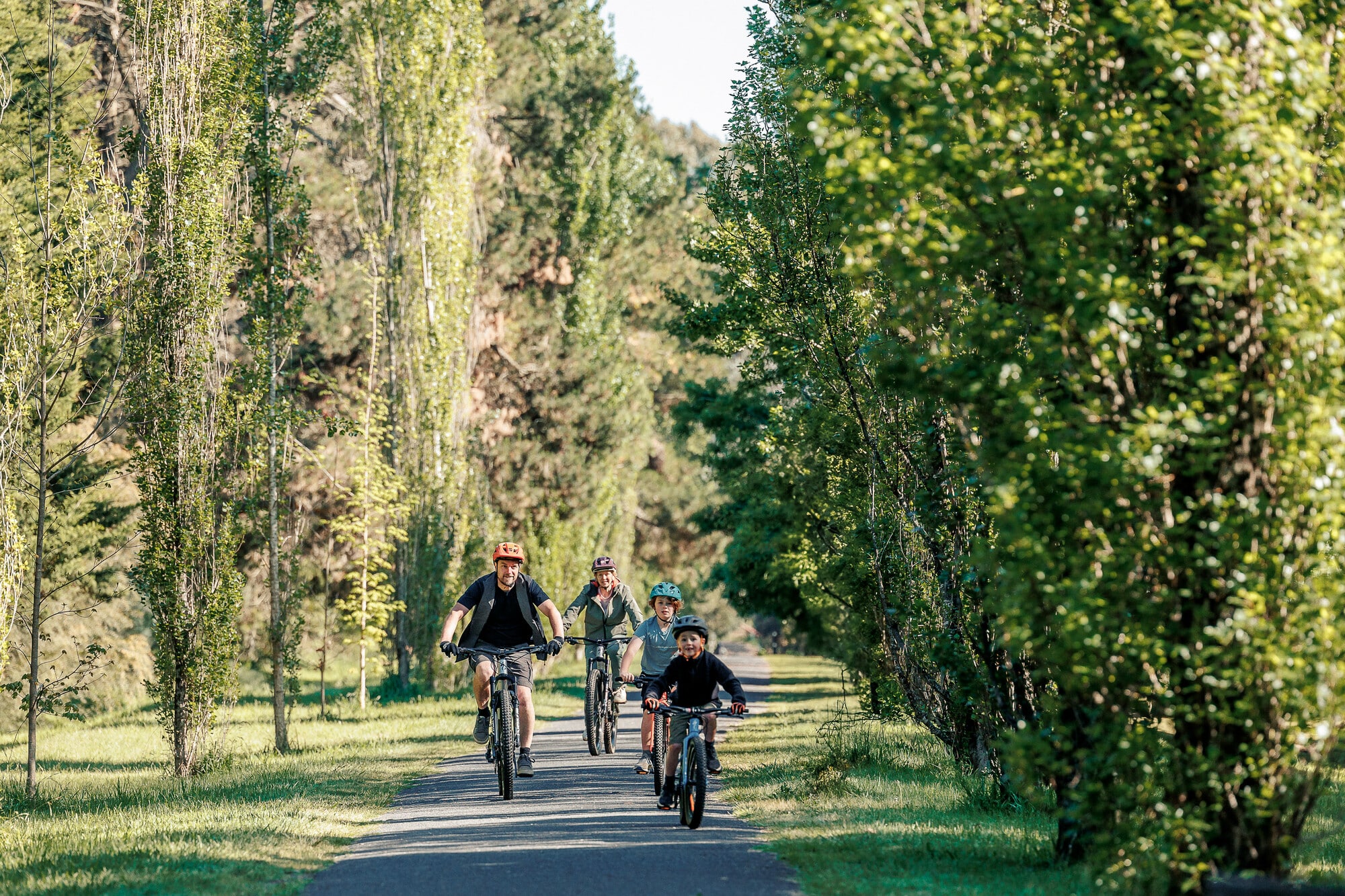 A family riding through spring new growth in Porepunkah on the Murray to Mountains Rail Trail