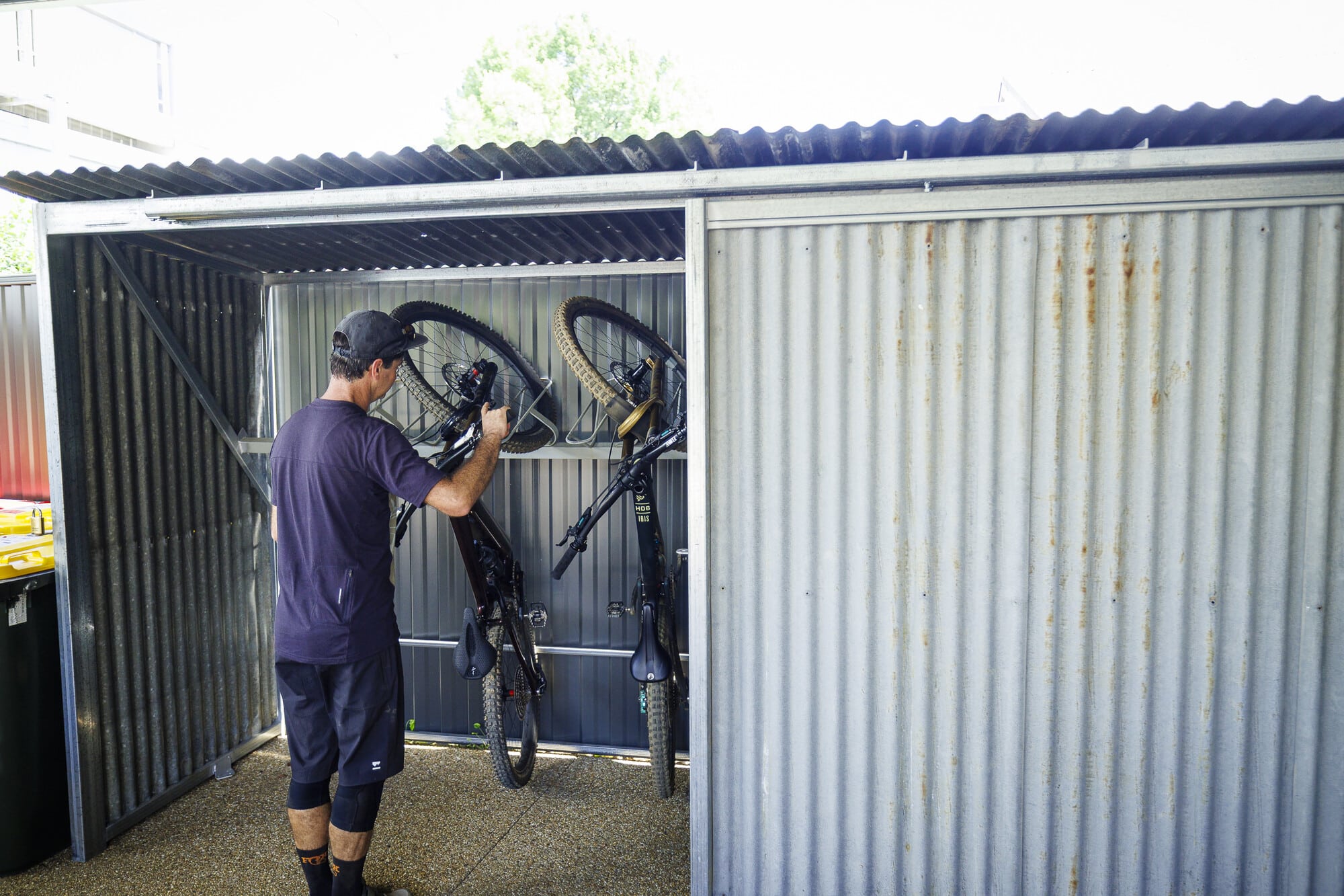 Cyclist placing their bike in secure bike storage at Bright Boutique Accommodation.
