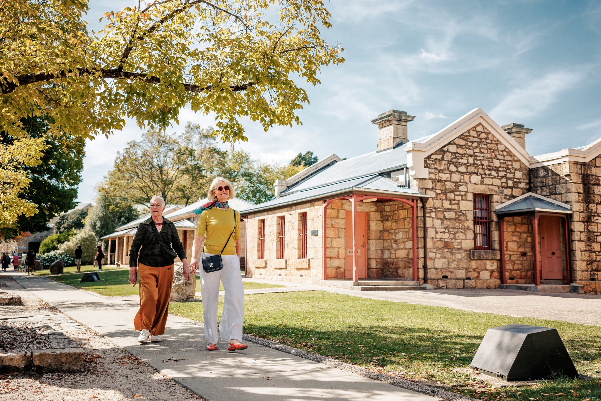 Two people walking past the gold rush buildings in the Beechworth Historic Precinct