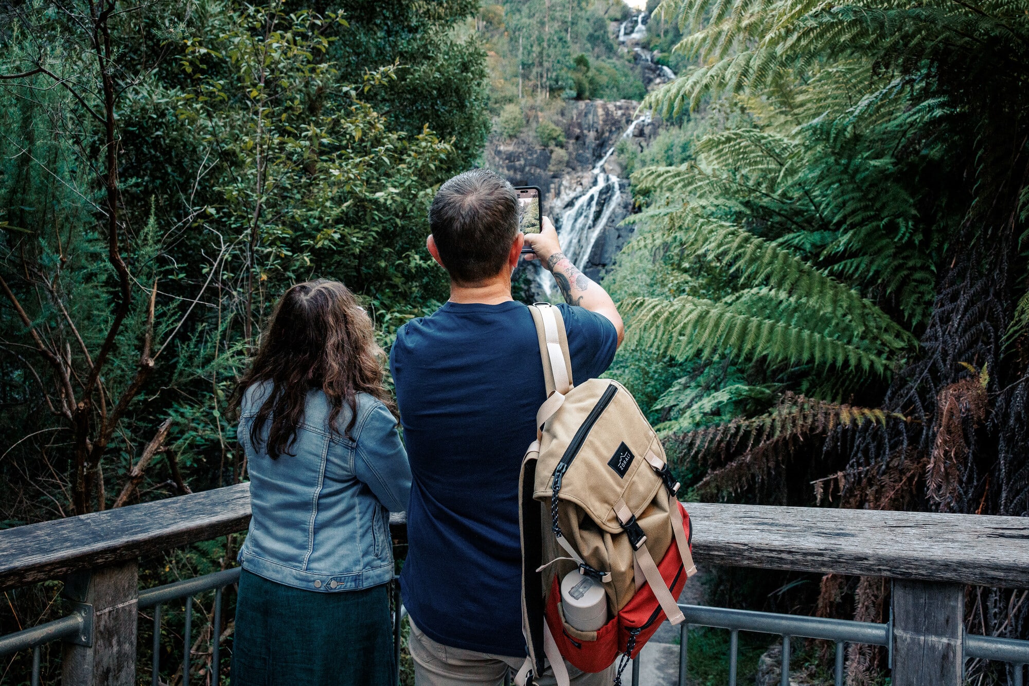 Two people taking a picture of Steavenson Falls in Marysville.