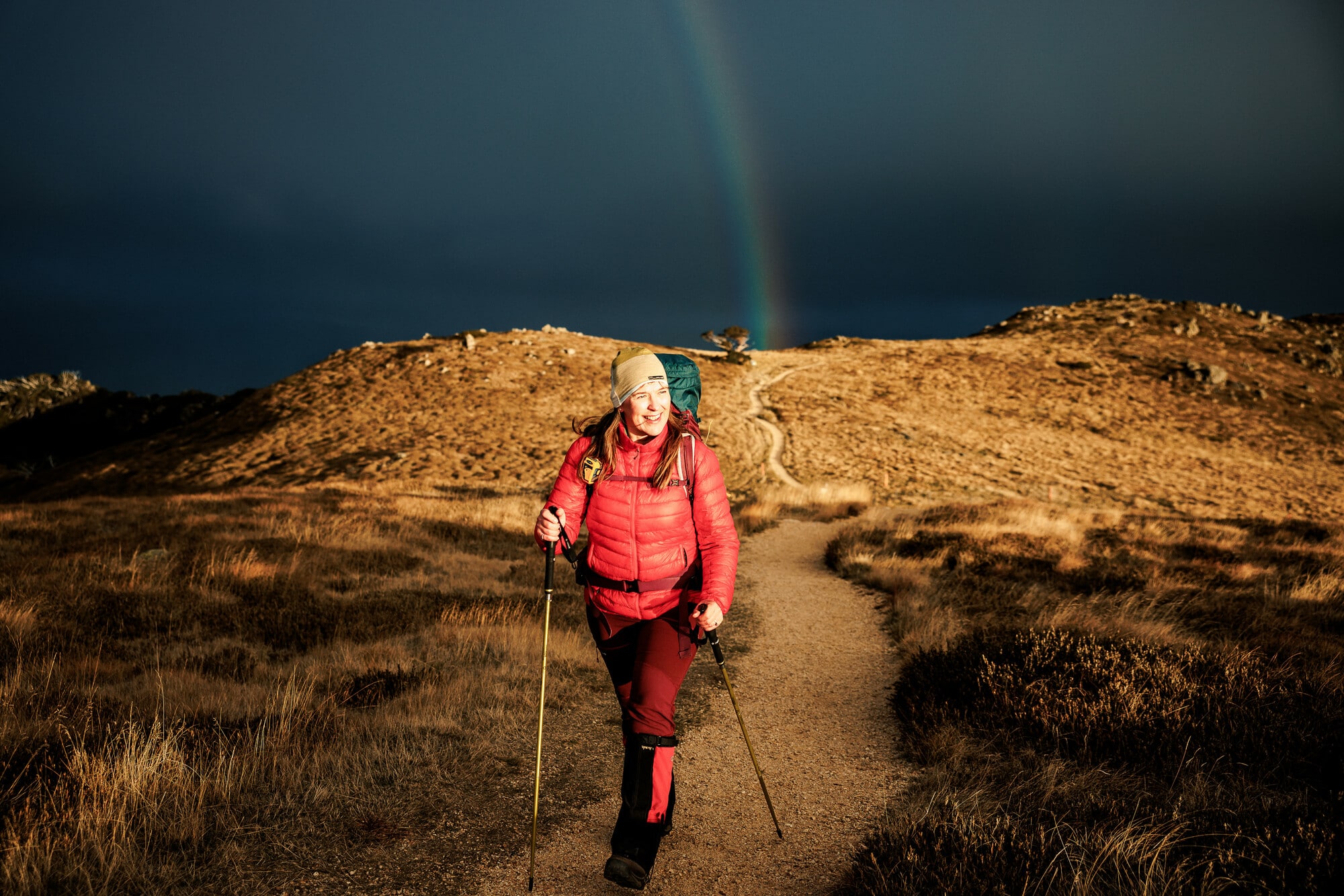 Person hiking to Mt Stirling summit's with a rainbow in the background