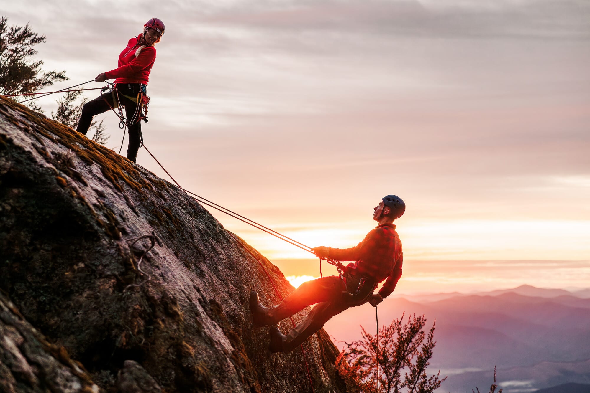Person abseiling on Mount Buffalo's cliffs with Adventure Guides Australia with mountain views in the background
