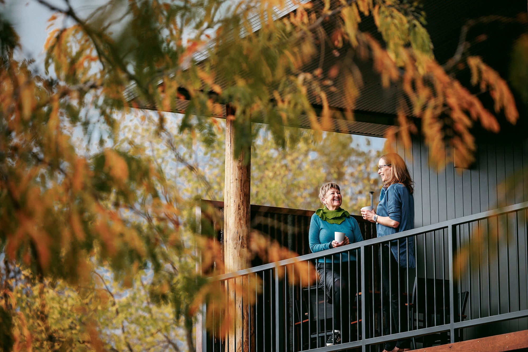Two people relaxing on the balcony at Rocky Valley Luxury Apartments