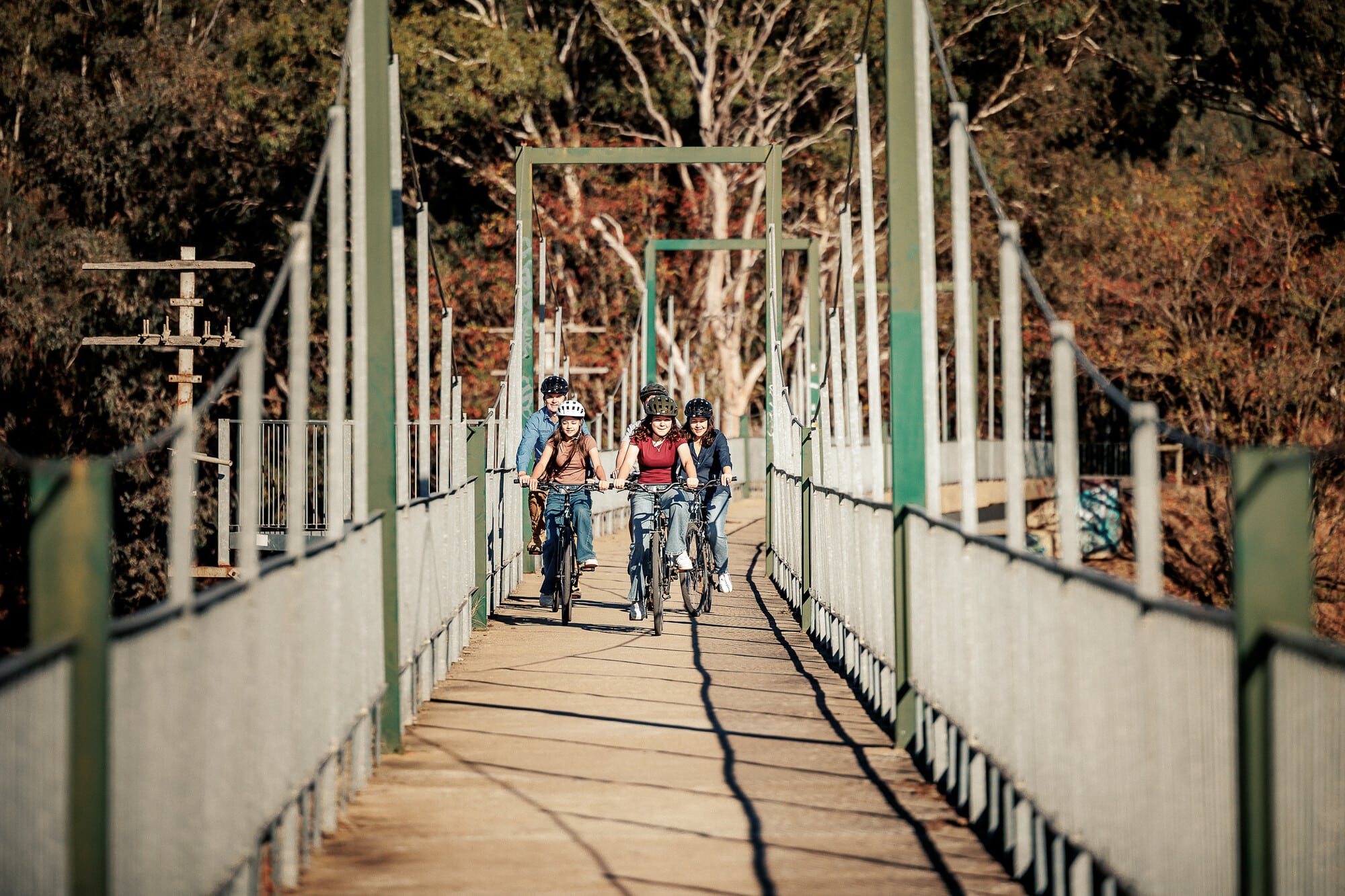 Group of cyclists riding over a bridge at Bonnie Doon.