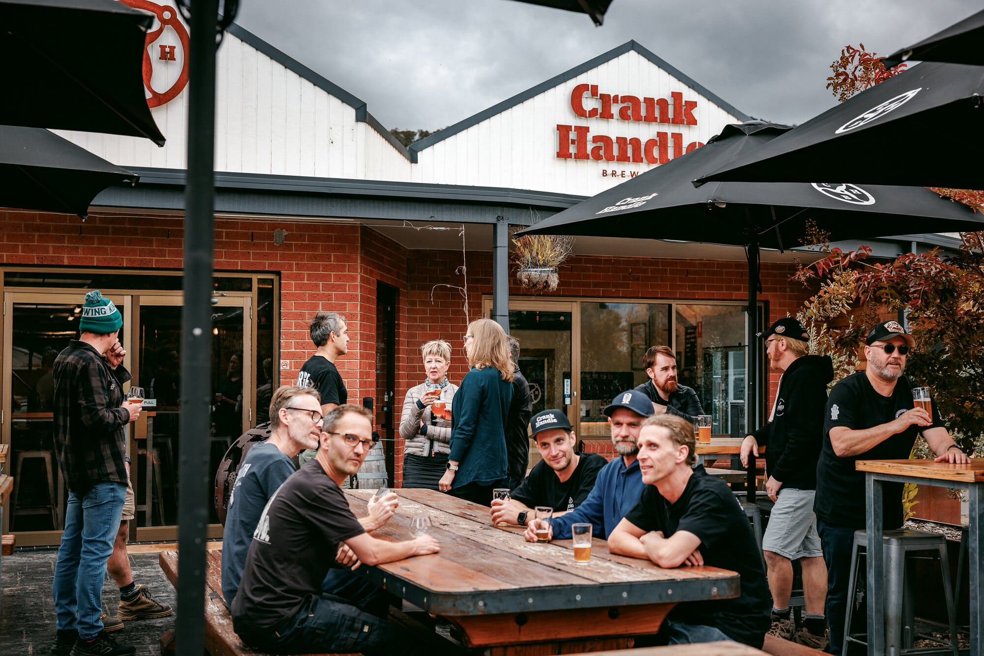 Group of people enjoying beers in the outdoors beer garden at Crank Handle Brewery.