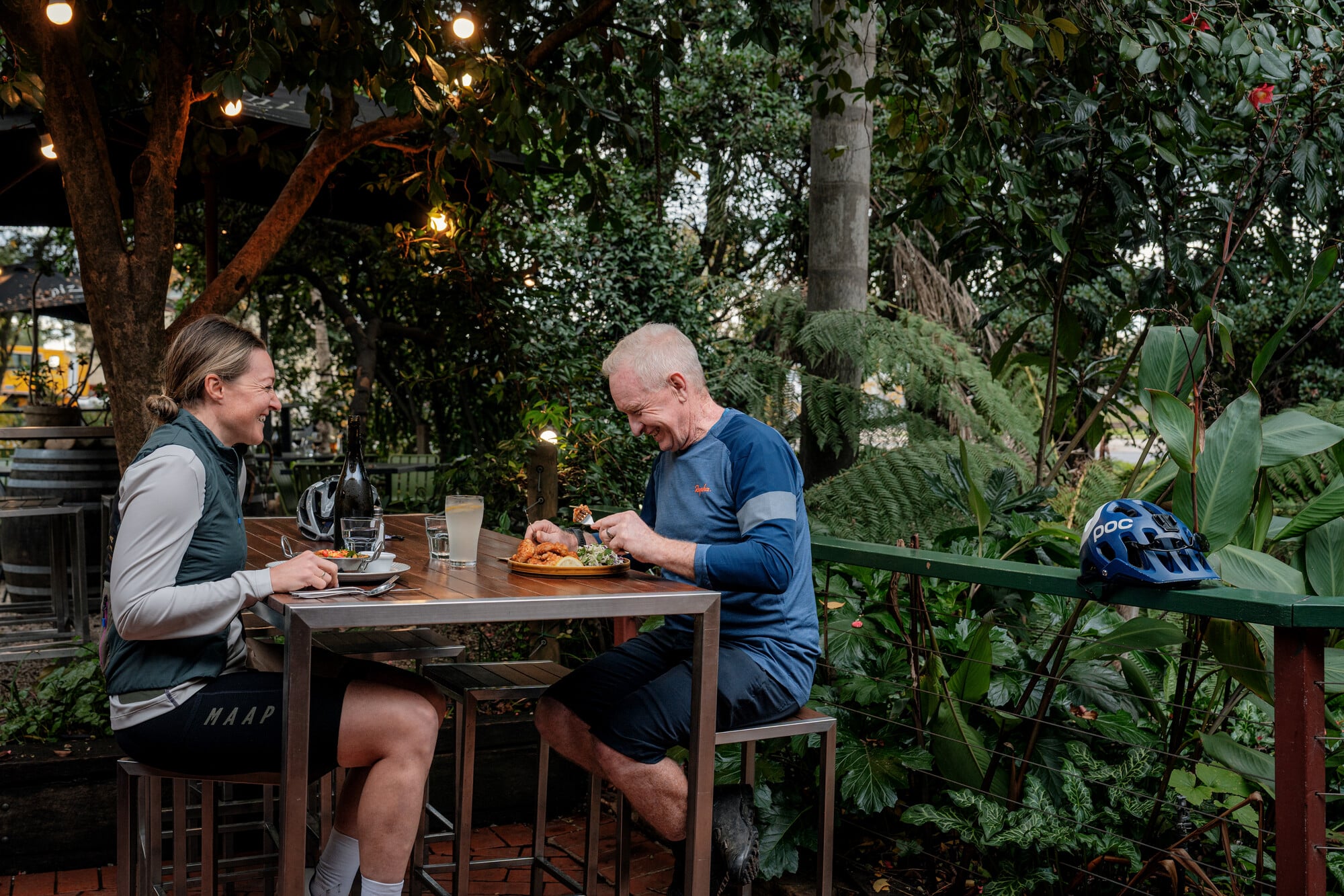 Two cyclists enjoying a meal at Mountain View Hotel in the courtyard.