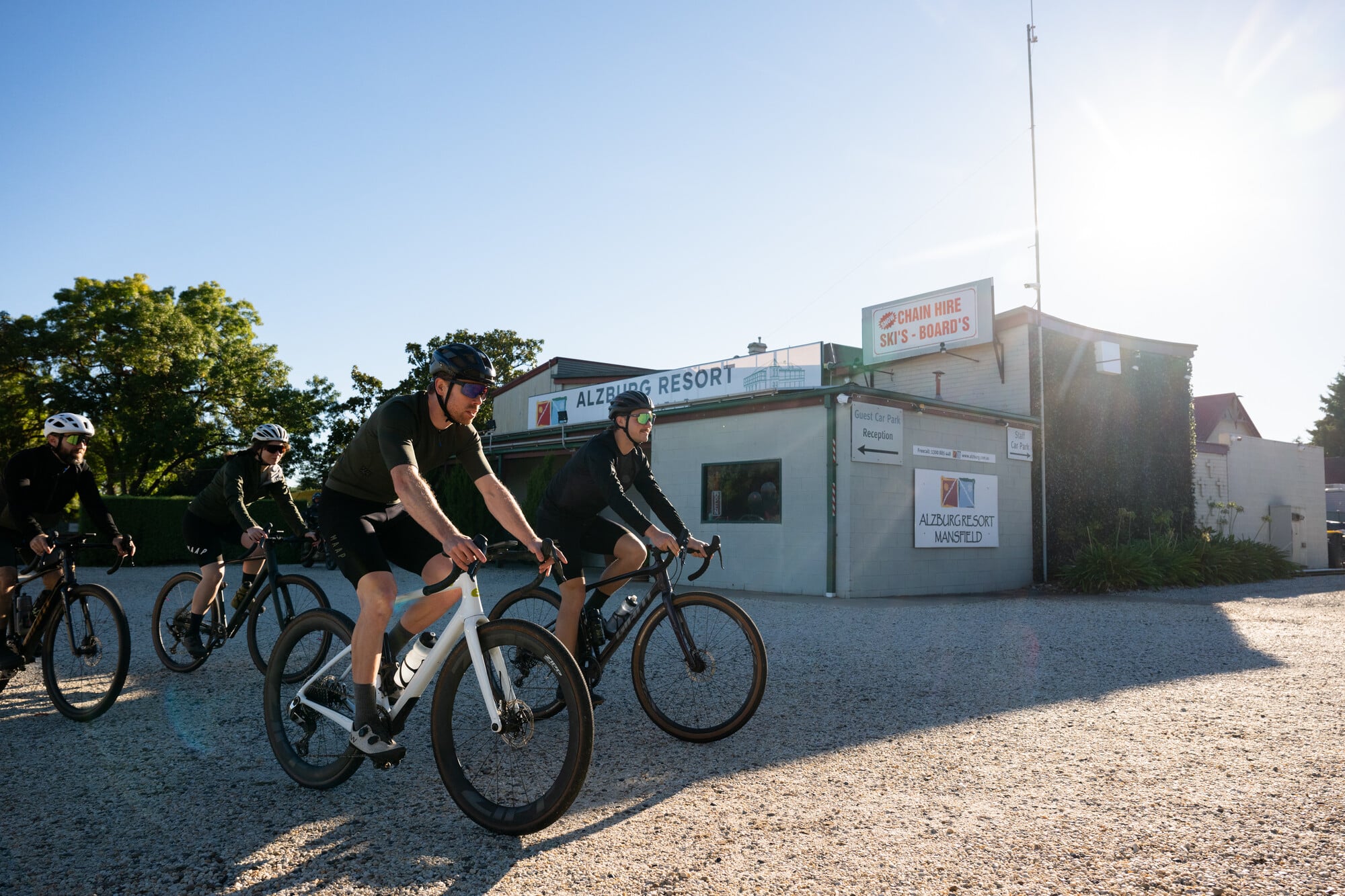 Group of gravel cyclists riding from Alzburg Resort on a sunny day.