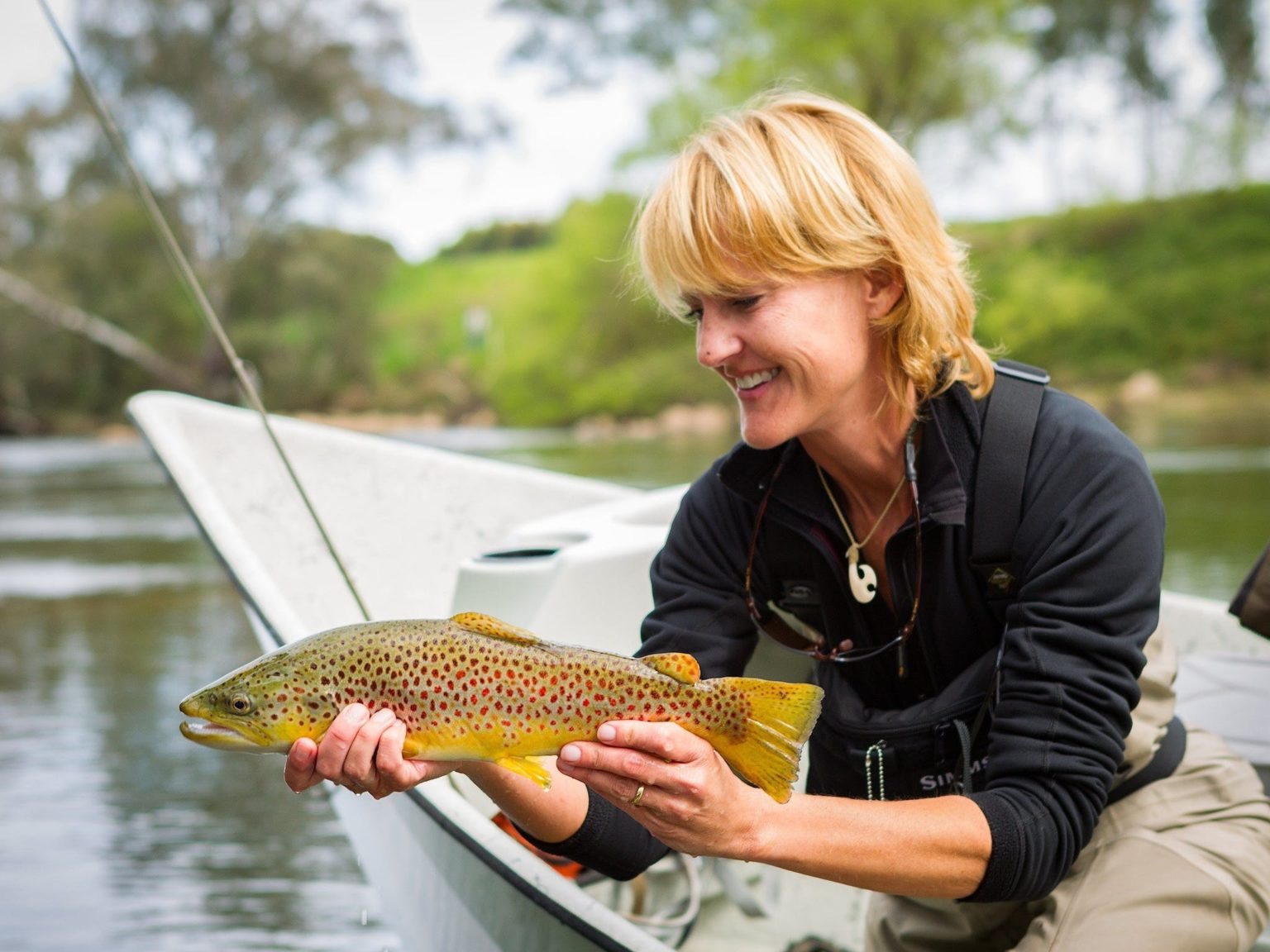Lady gently cradling a brown trout just prior to release
