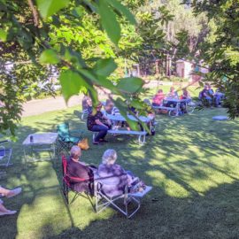 Community enjoying picnic in Park litening to music